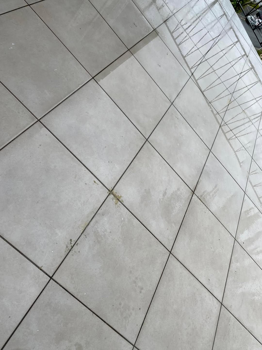 Before restoration: outdoor tiled area with dirt and staining